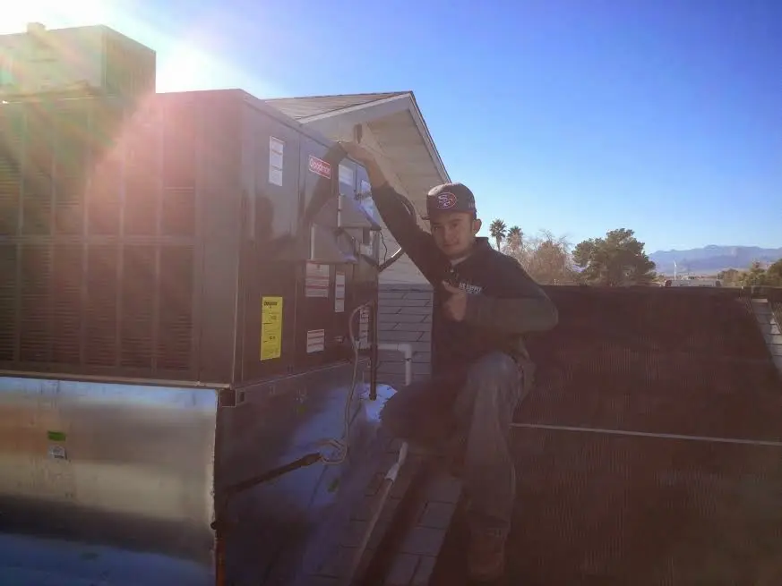 HVAC technician performing AC Tune-Up on a rooftop unit in Perkasie