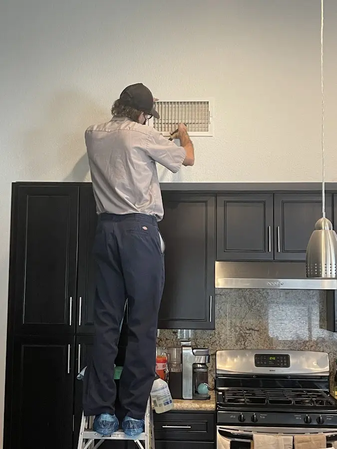 Technician inspecting an air vent during HVAC service in Perkasie